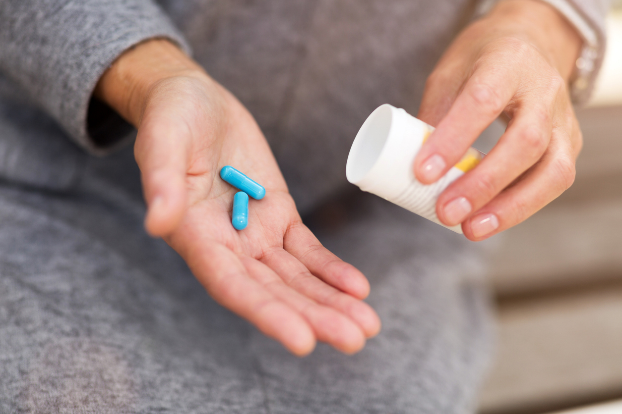 Elderly woman holding pills